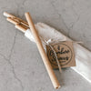 Set of four bamboo straws with organic cotton pouch on a textured surface.